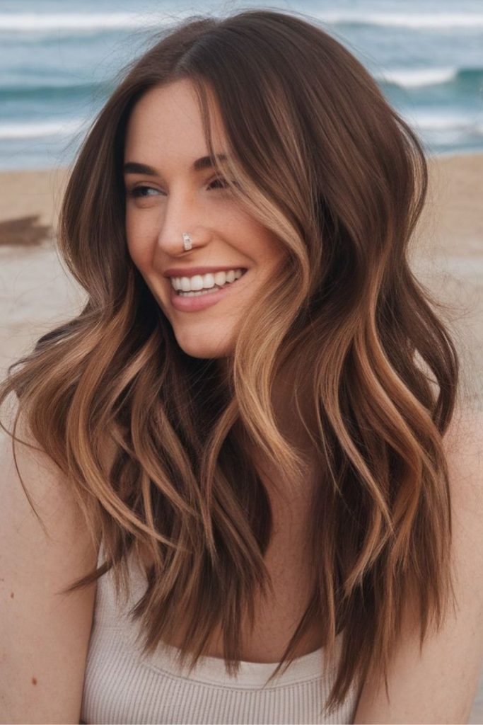 Sandstone brunette wavy highlighted hairstyle.