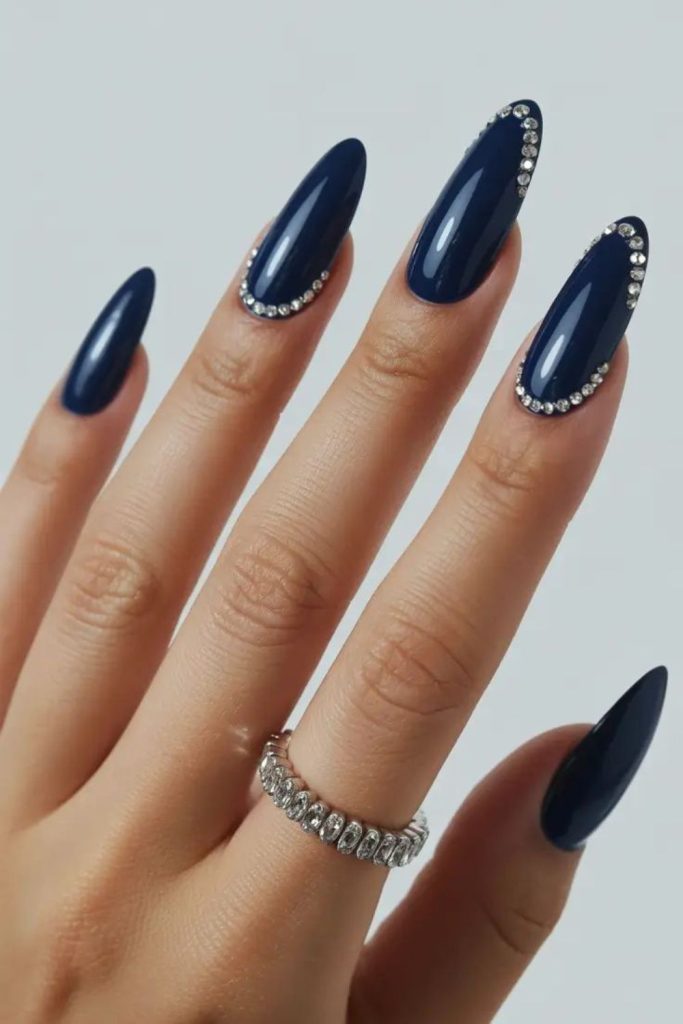 Navy blue graduation nails with gems.