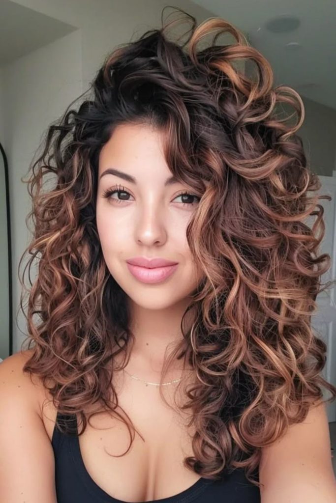 Side swept dramatic curly hairstyle bold asymmetry