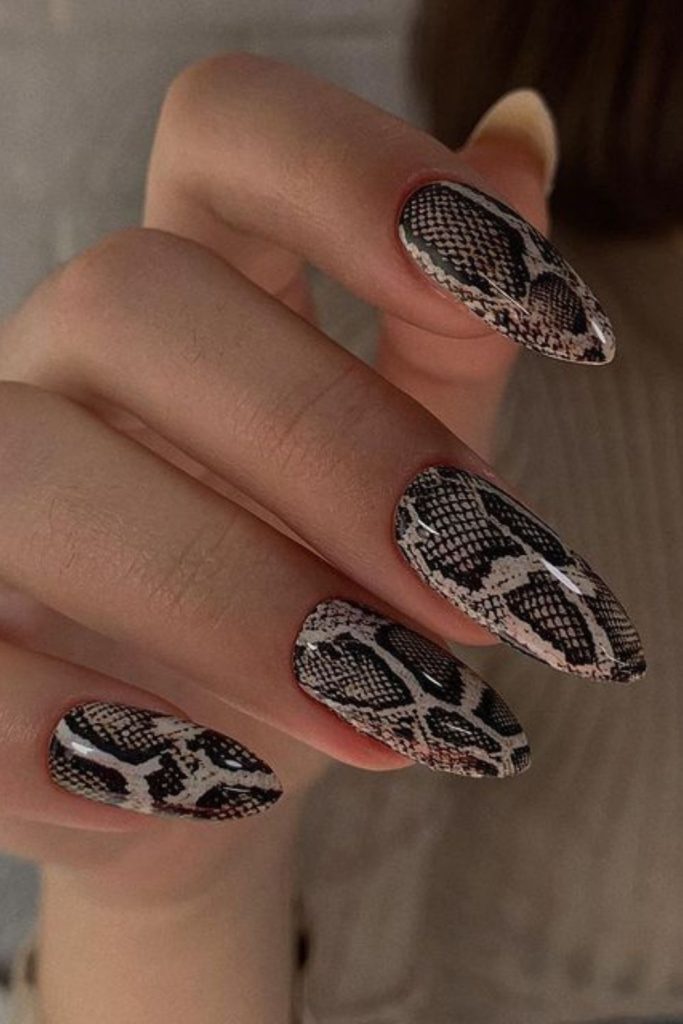 Snake print edgy pointed nails.