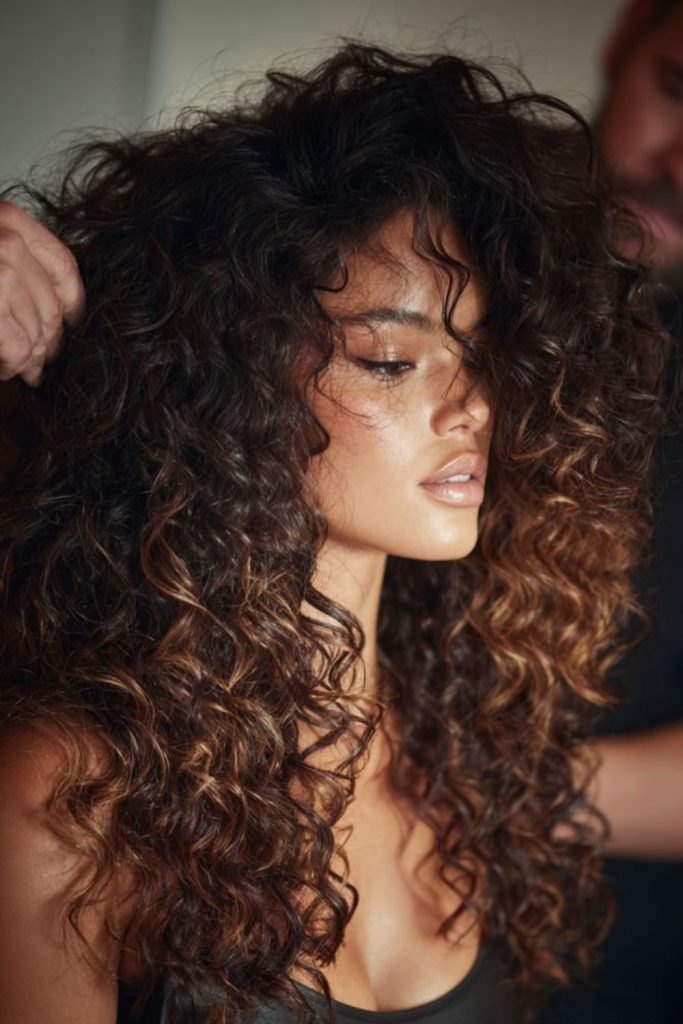Dramatic curly hairstyle with soft powerful volume.