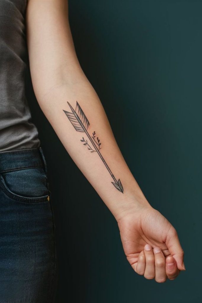 Minimal arrow tattoo symbolizing determination.