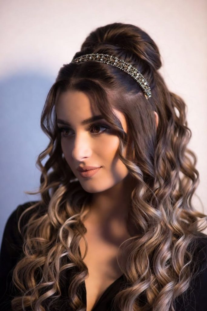 Decorative headband with voluminous curly hairstyle.