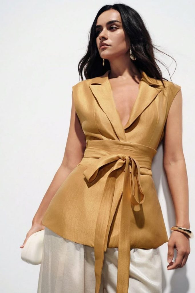 Golden toned sleeveless blazer evening look