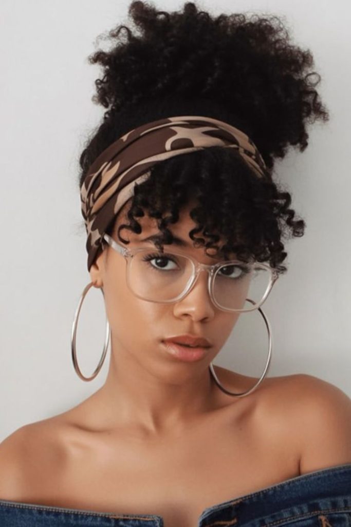 Puffy hairstyle framed by wide headband.