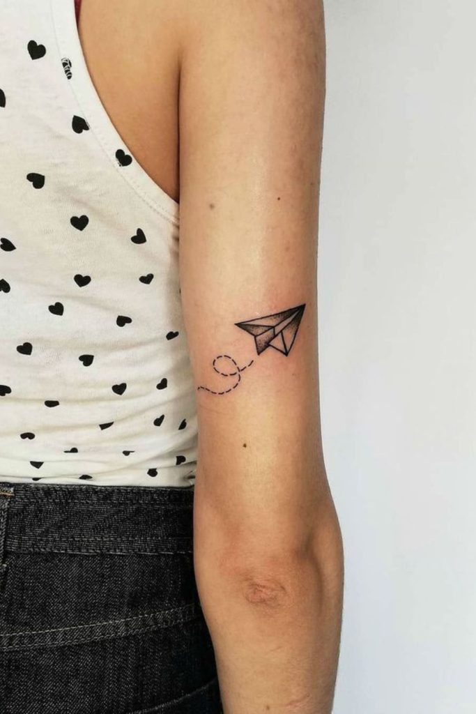 Small paper airplane minimalist tattoo style.