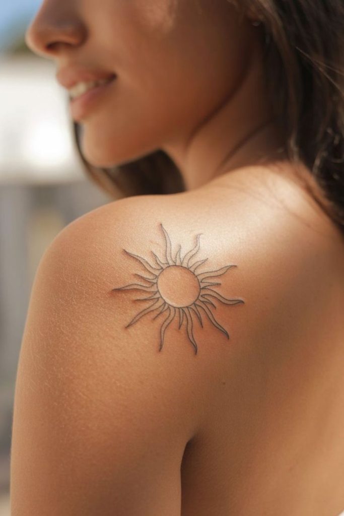 Small sun tattoo with rays.