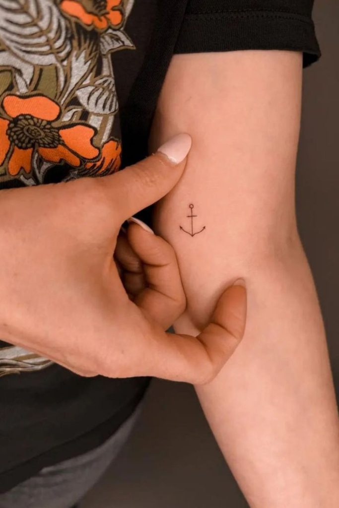 Small anchor tattoo with nautical charm.