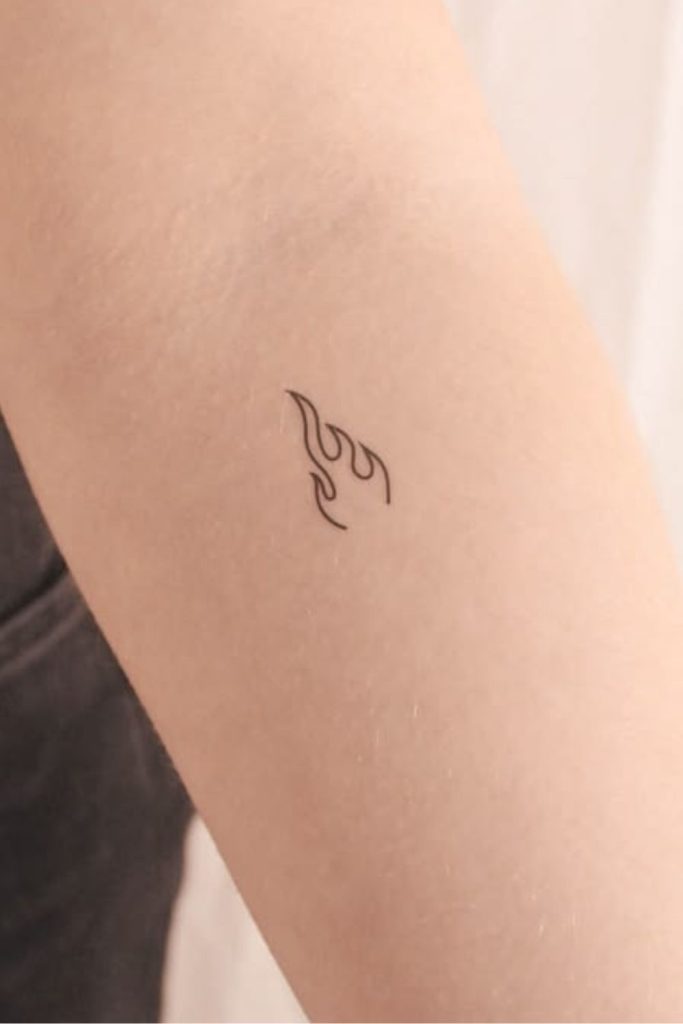 Tiny flame tattoo with bold energy.