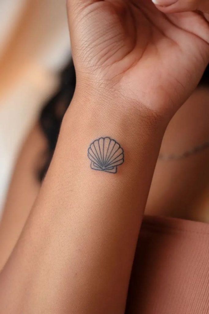 Tiny seashell tattoo with coastal charm.
