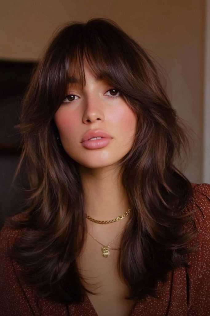 Curtain bangs with flowing layered hair.