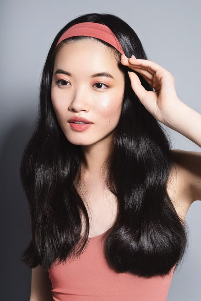 Flowing wavy hairstyle with wide headband.