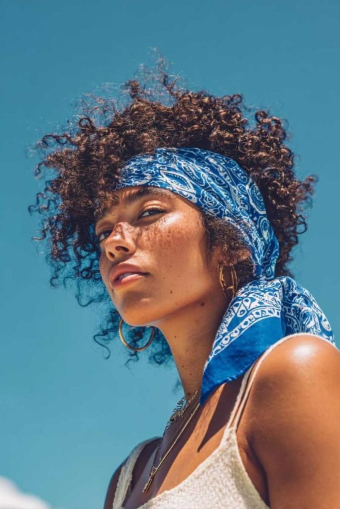 Afro puff framed by vibrant bandana.