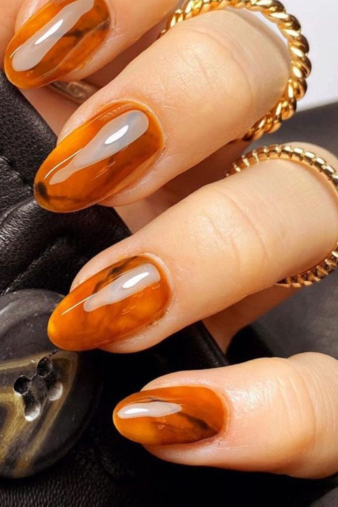 Amber crystal shimmering nail art design.