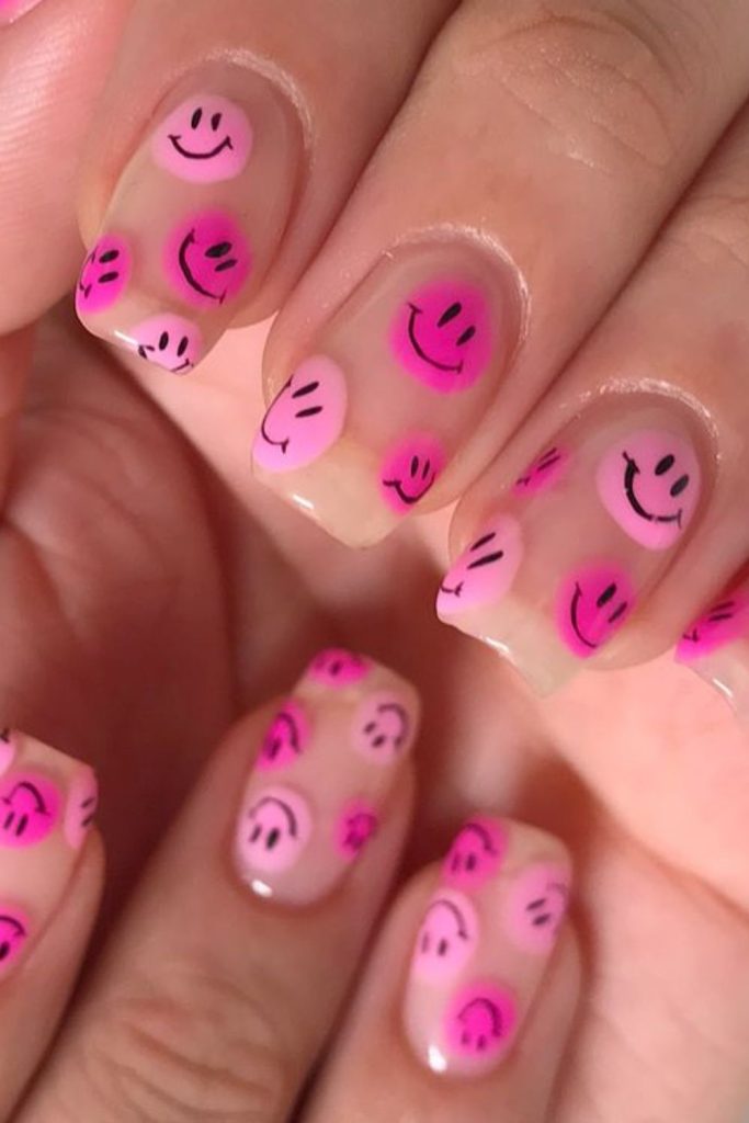 Pink smiley face cheerful nail design.
