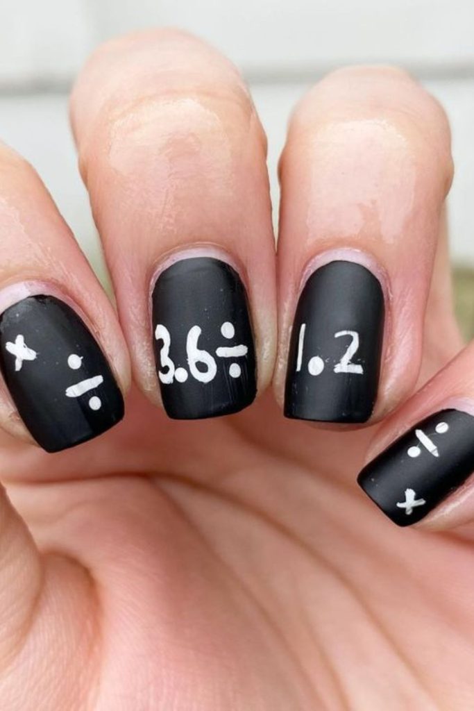 Chalkboard-inspired black school nail design.