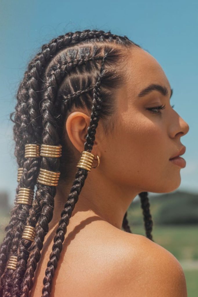 Cornrows adorned with golden braid cuffs.