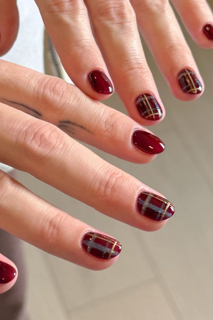 Burgundy plaid accent autumn nail design.