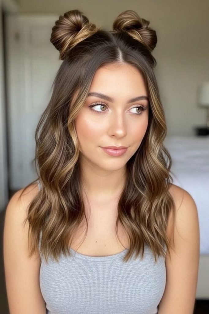 Half-up space buns with curls.