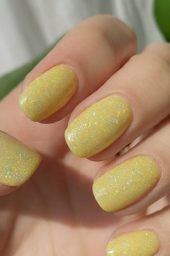 Pastel yellow glitter school nails.