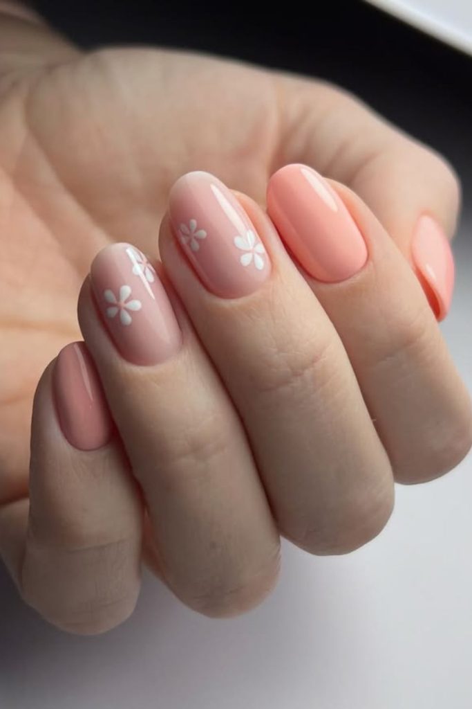 Peach nails with delicate floral accents.