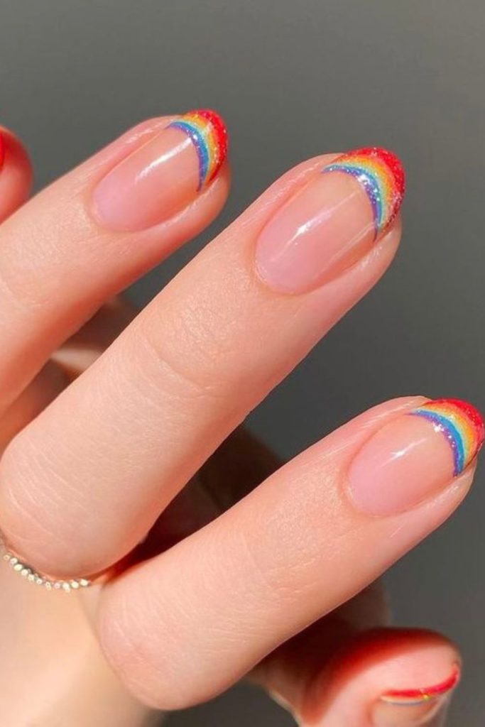 Colorful rainbow French tip manicure.
