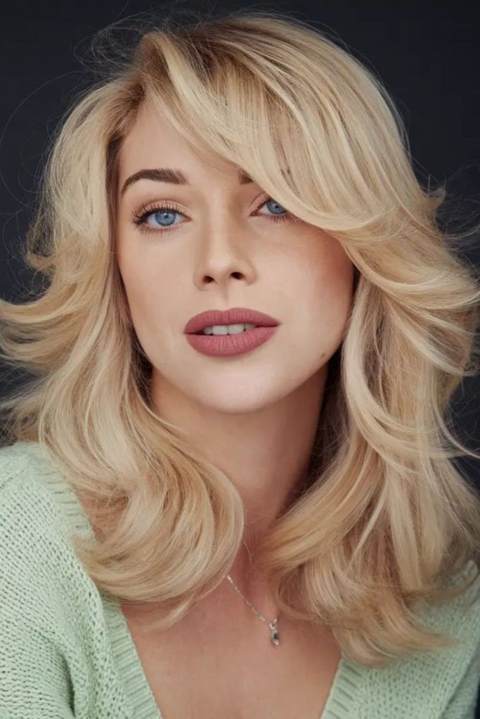Sculpted Side Glam with dramatic sweeping bangs.