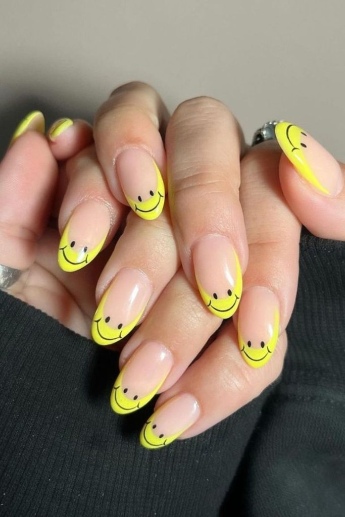 Yellow smiley face accent nail design.