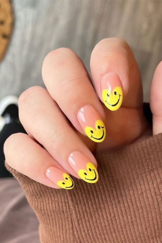 Smiley face nails with hearts.