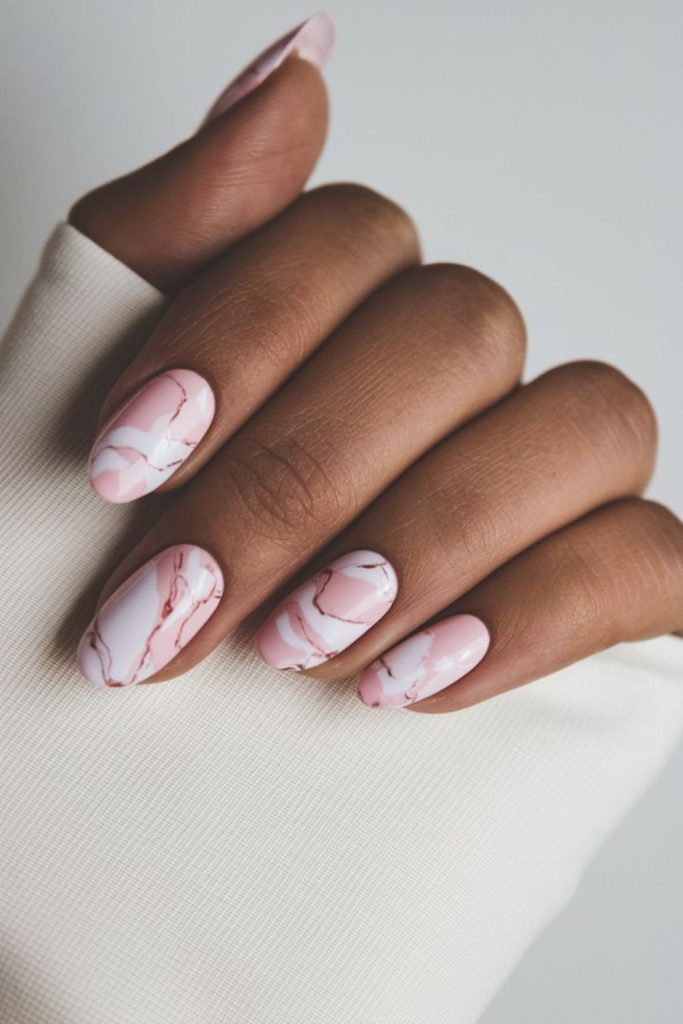 Strawberry milk nails with pink swirls.