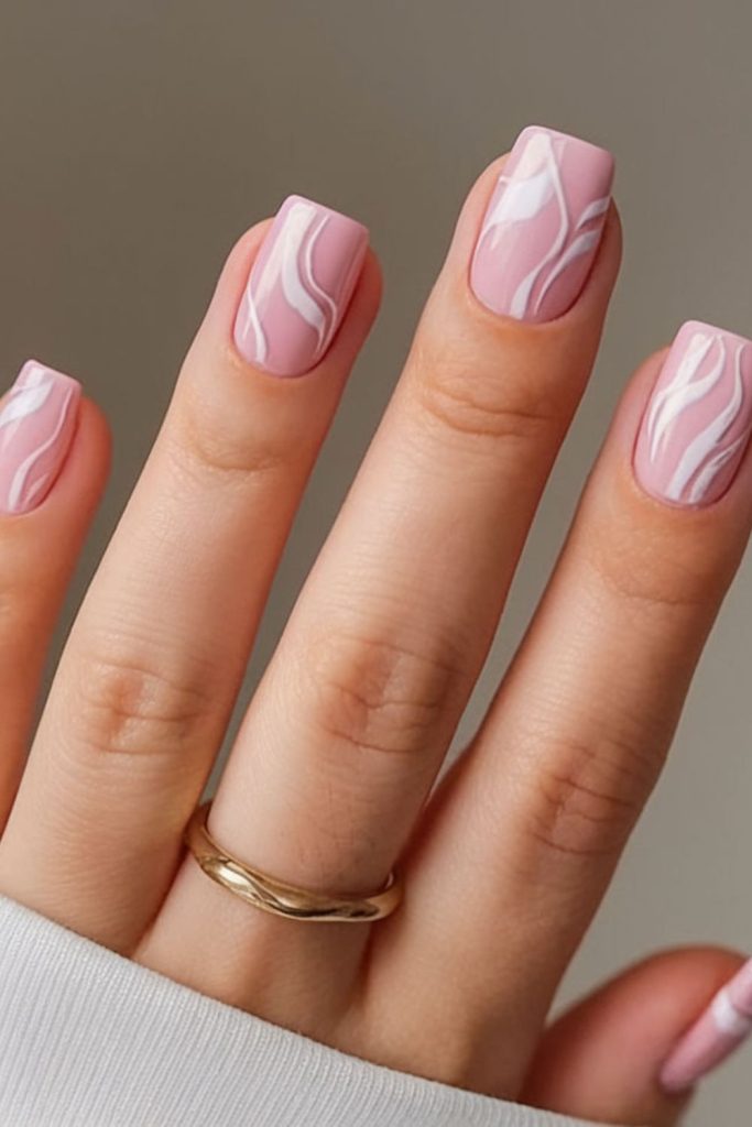 Pink and white swirl nails.