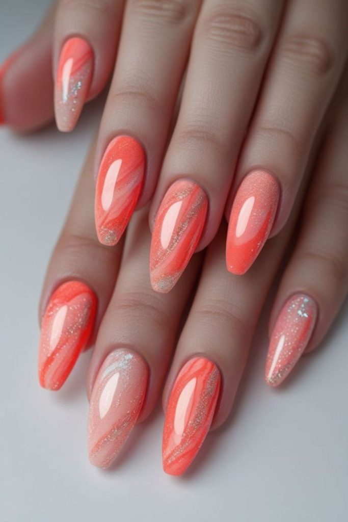 Glossy coral nails with white swirls.