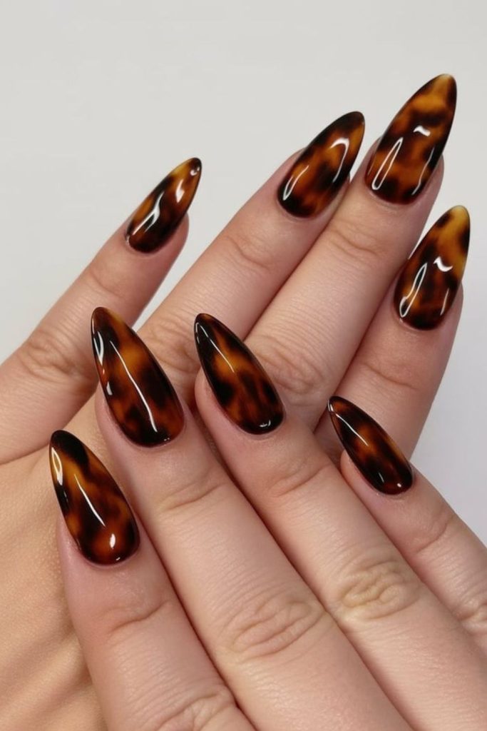 Tortoiseshell nails with warm caramel patterns.
