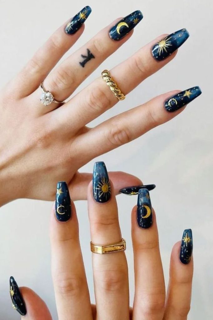 Celestial navy nails with moon designs.