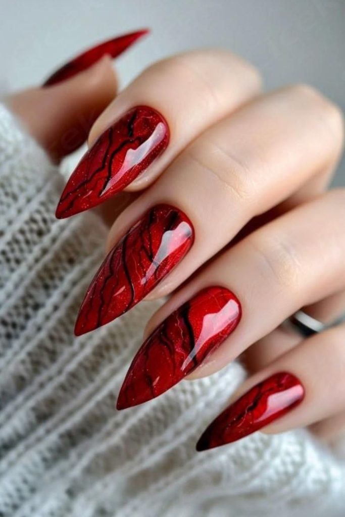 Crimson burgundy nails with gothic symbols.