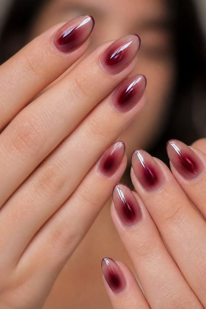 Glowing oxblood aura almond manicure.