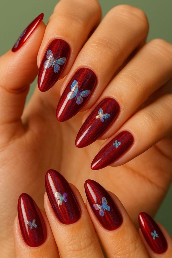 Sparkling oxblood butterfly nail design.