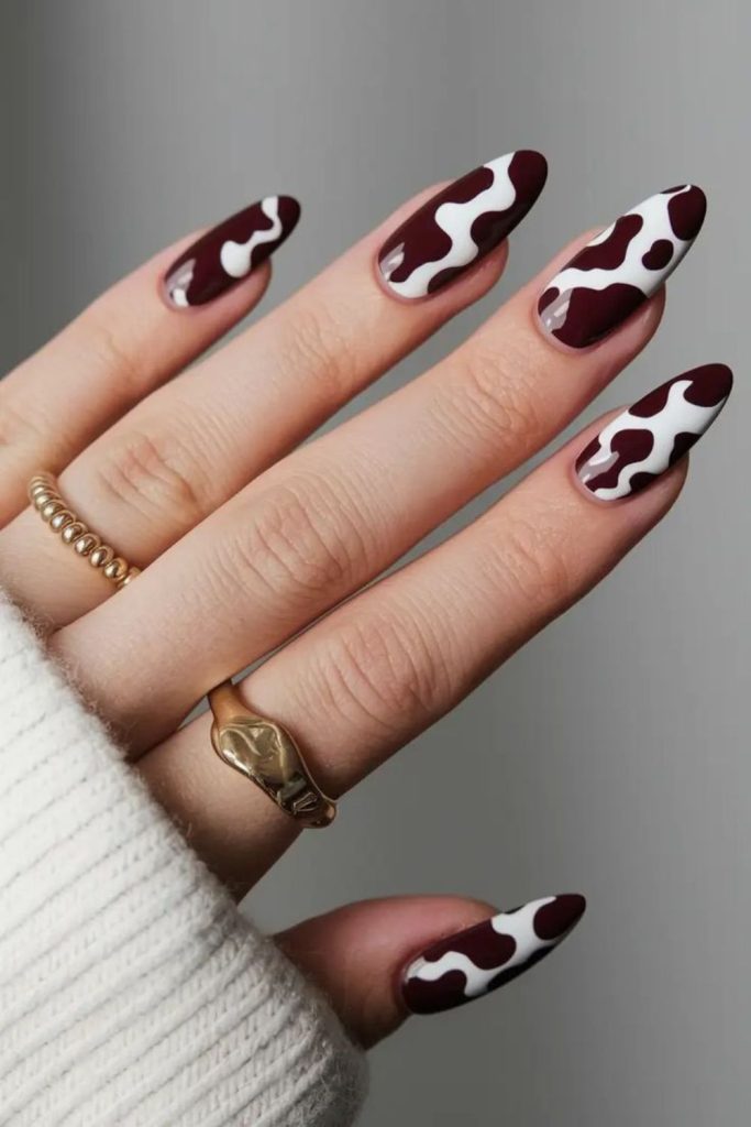 Trendy oxblood cow print nails.