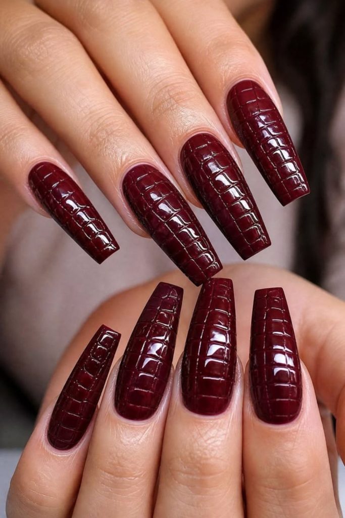 Textured oxblood crocodile effect nails.