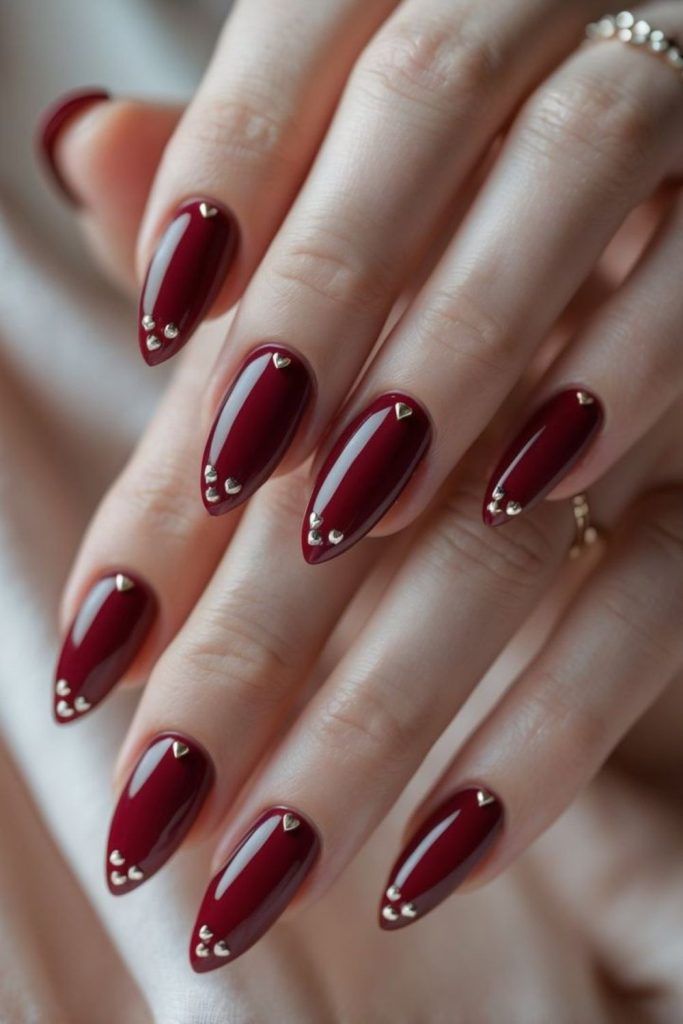 Elegant oxblood pearl accent manicure.