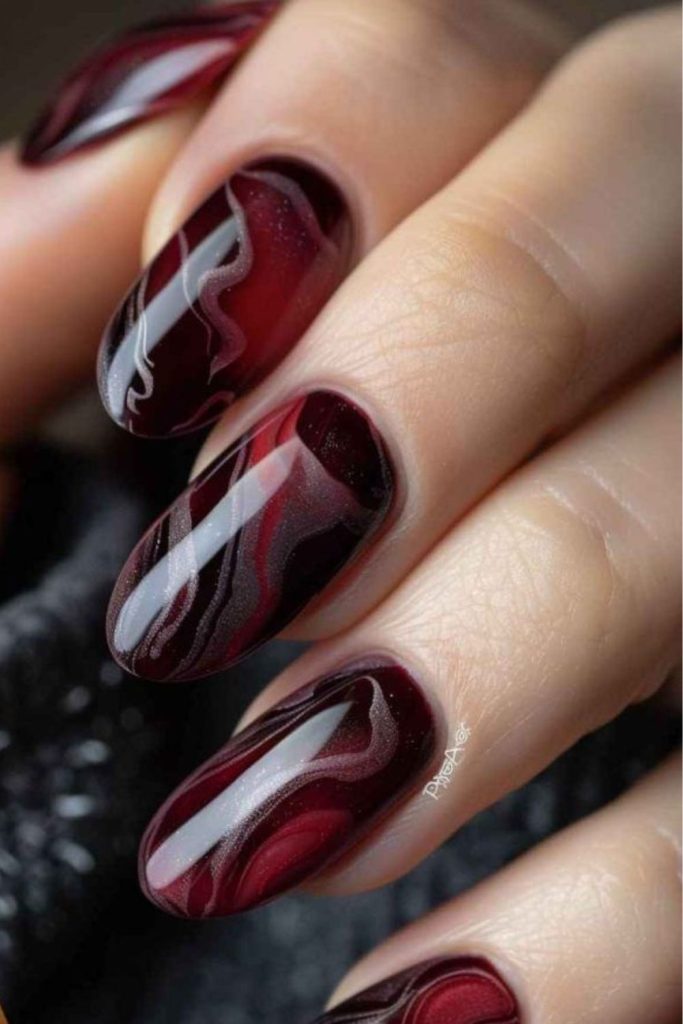 Elegant oxblood swirling nail art.