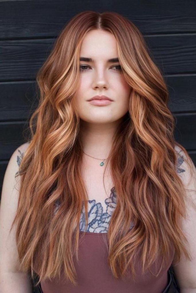 Strawberry brunette hair with face-framing highlights.