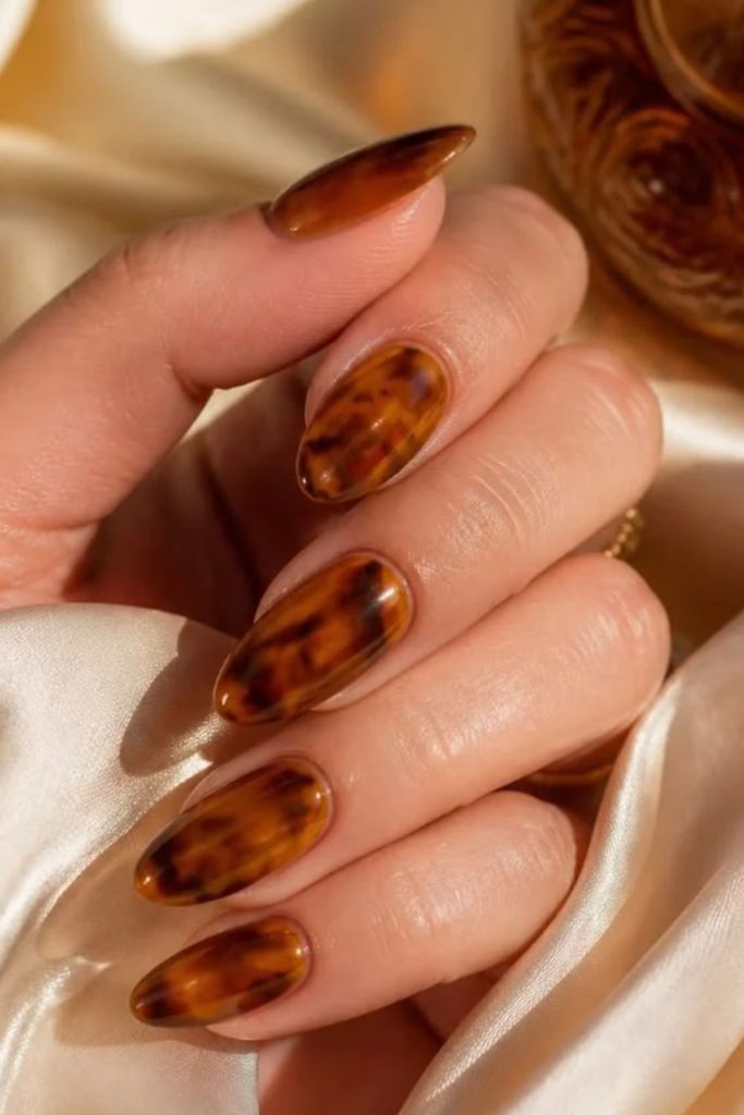 Amber tortoiseshell nails with glossy finish.