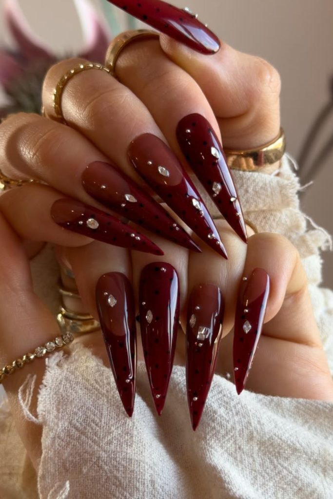 Burgundy butterfly stiletto nail art.