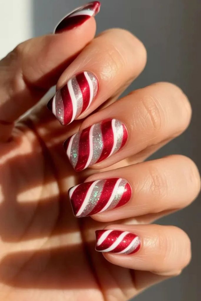 Shiny red white candy cane chrome nails.