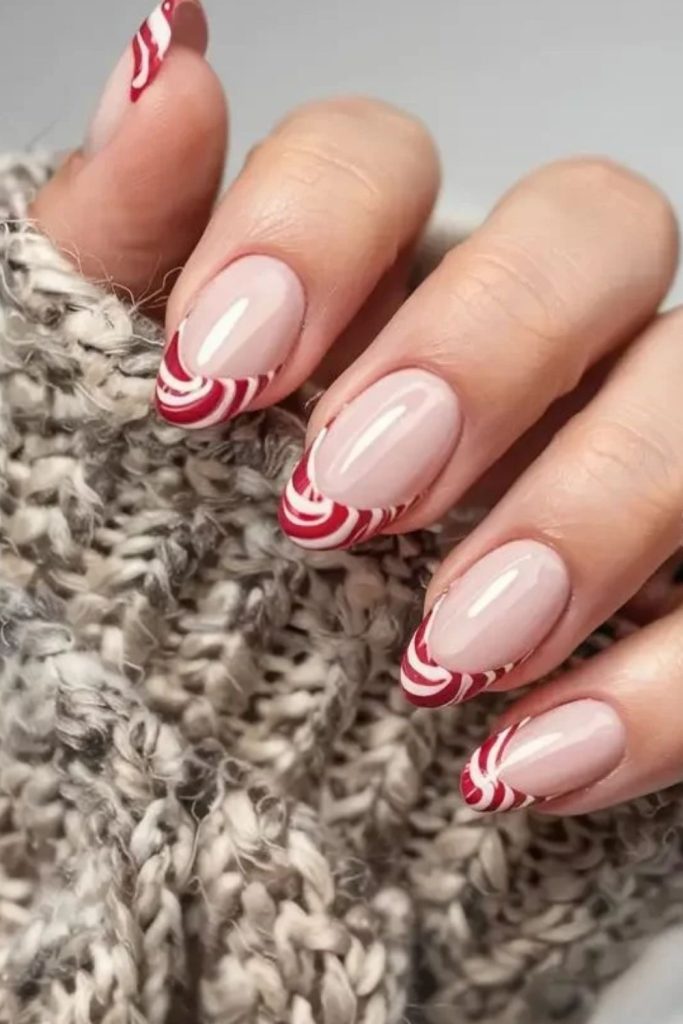 Curved peppermint swirl French tip nails.