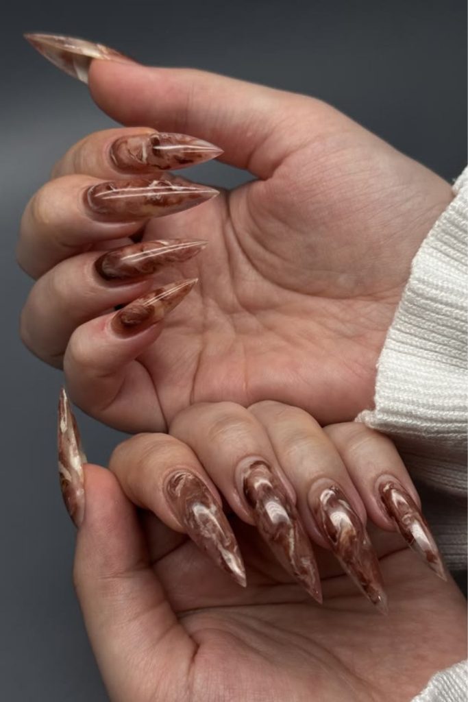 Caramel marble neutral stiletto nails.