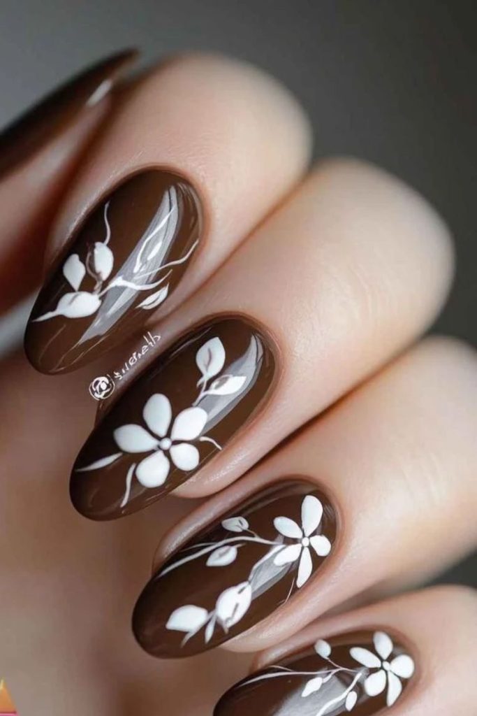 Chocolate mocha nails with floral accents.