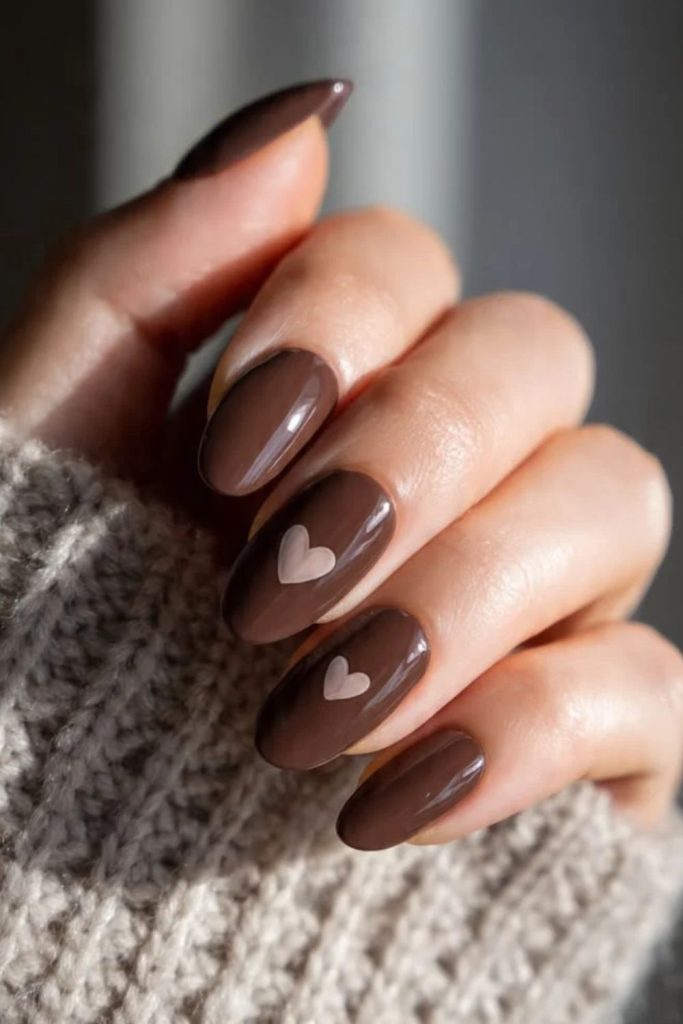 Cozy chocolate nails with cream hearts.