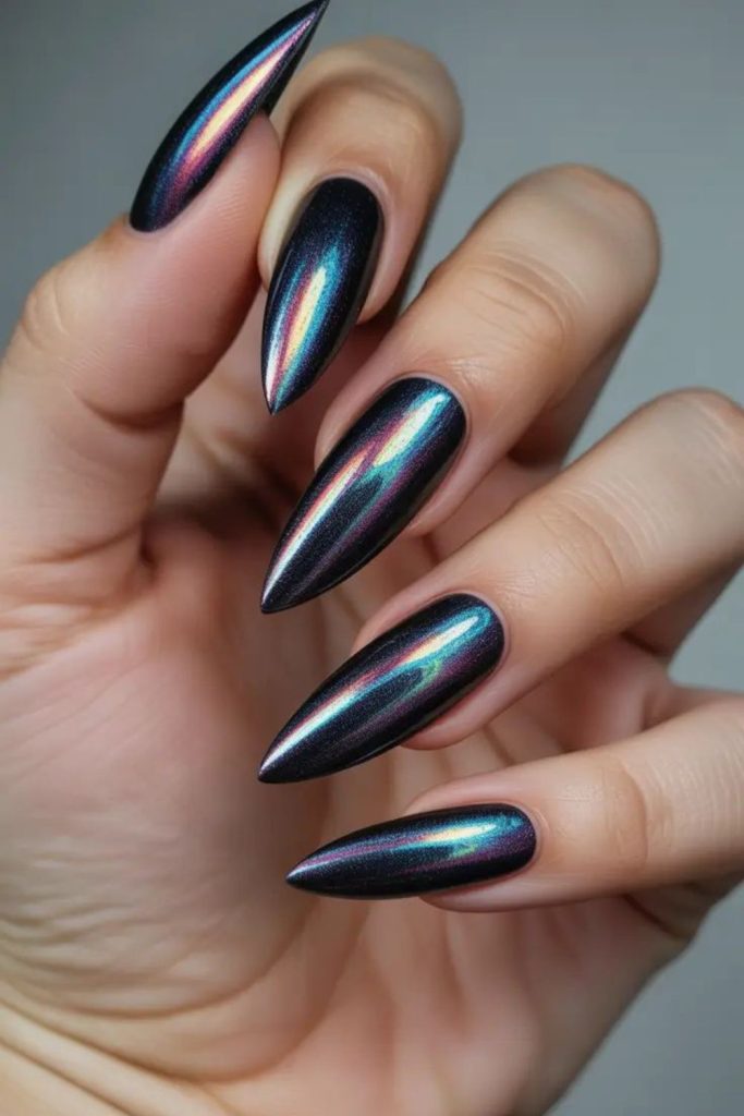Glossy black pointed stiletto nails.